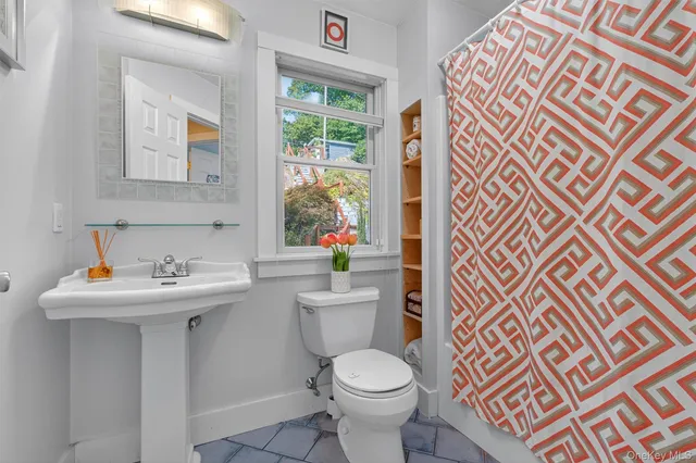 a bathroom with a sink mirror and a toilet