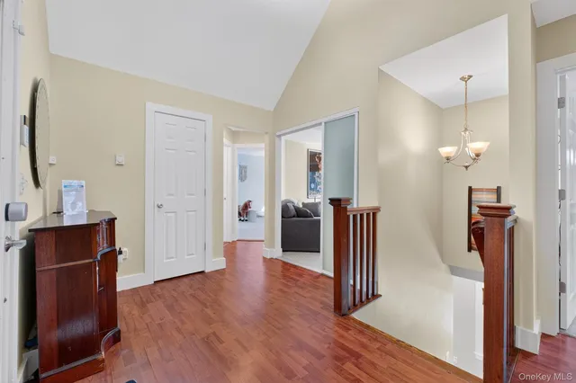 a view of a hallway with wooden floor and a cabinet