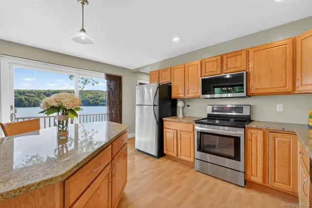 a kitchen with stainless steel appliances granite countertop a stove a sink and a refrigerator