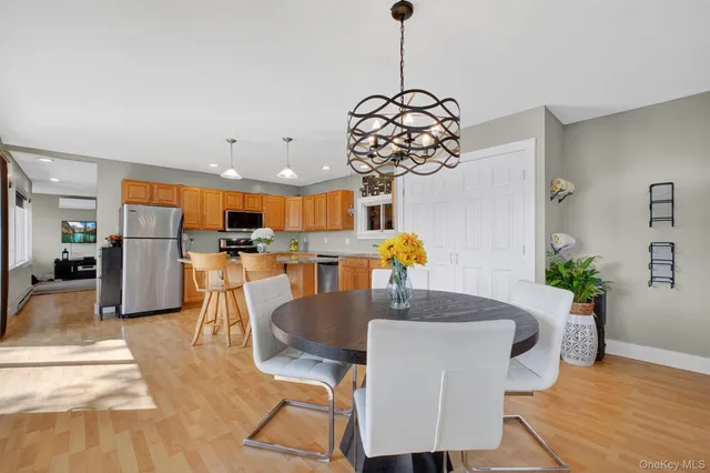 a dining room filled chandelier and kitchen view