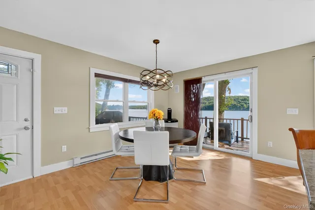 a dining room with wooden floor a chandelier a glass table and windows