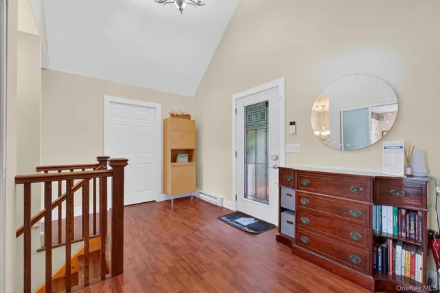 a view of a hallway with wooden floor and cabinet