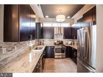 a kitchen with kitchen island granite countertop stainless steel appliances a sink and cabinets