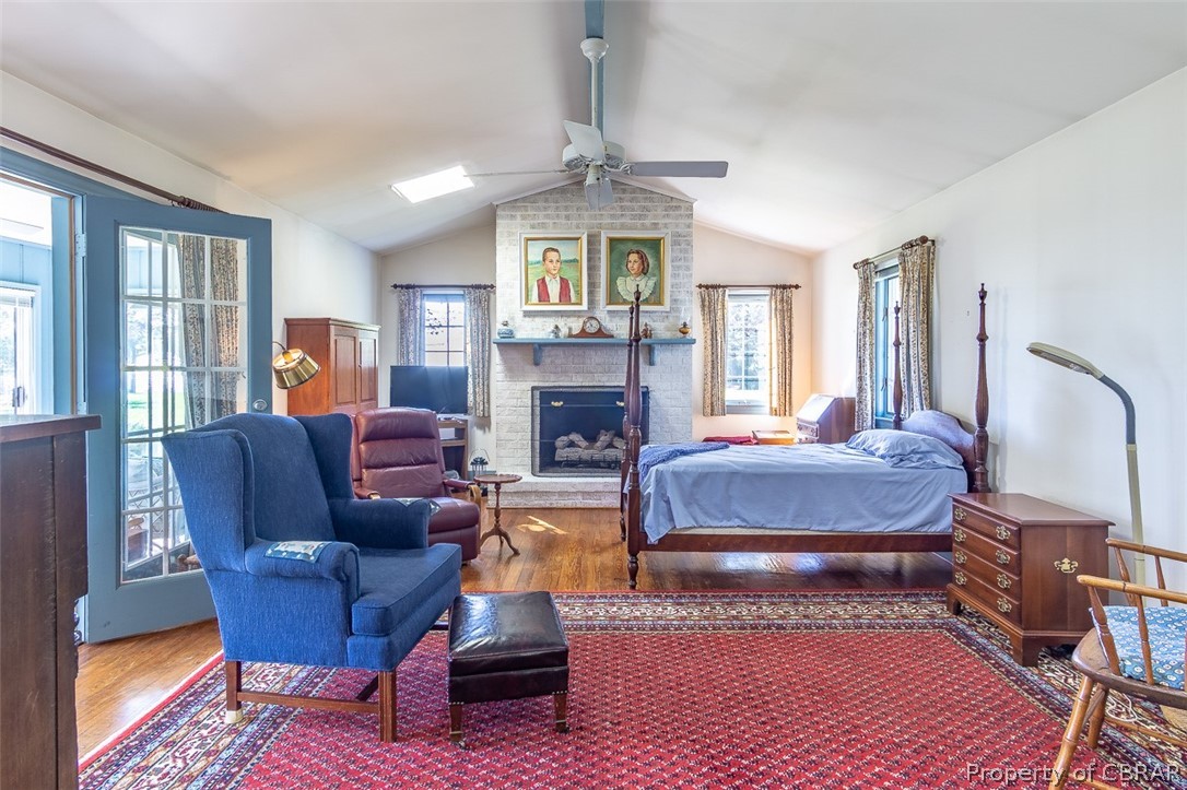 437 Taskmaker Lane Reedville, VA 22539 - Photo 27 of 38 Primary Bedroom with vaulted ceiling, hardwood floors, fireplace and entrance to sunroom