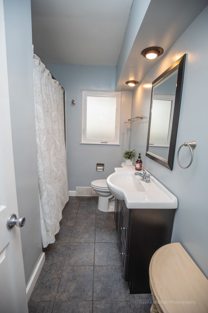 1610 Black Road Joliet, IL 60435 - Photo 13 of 25 a bathroom with a toilet sink and mirror