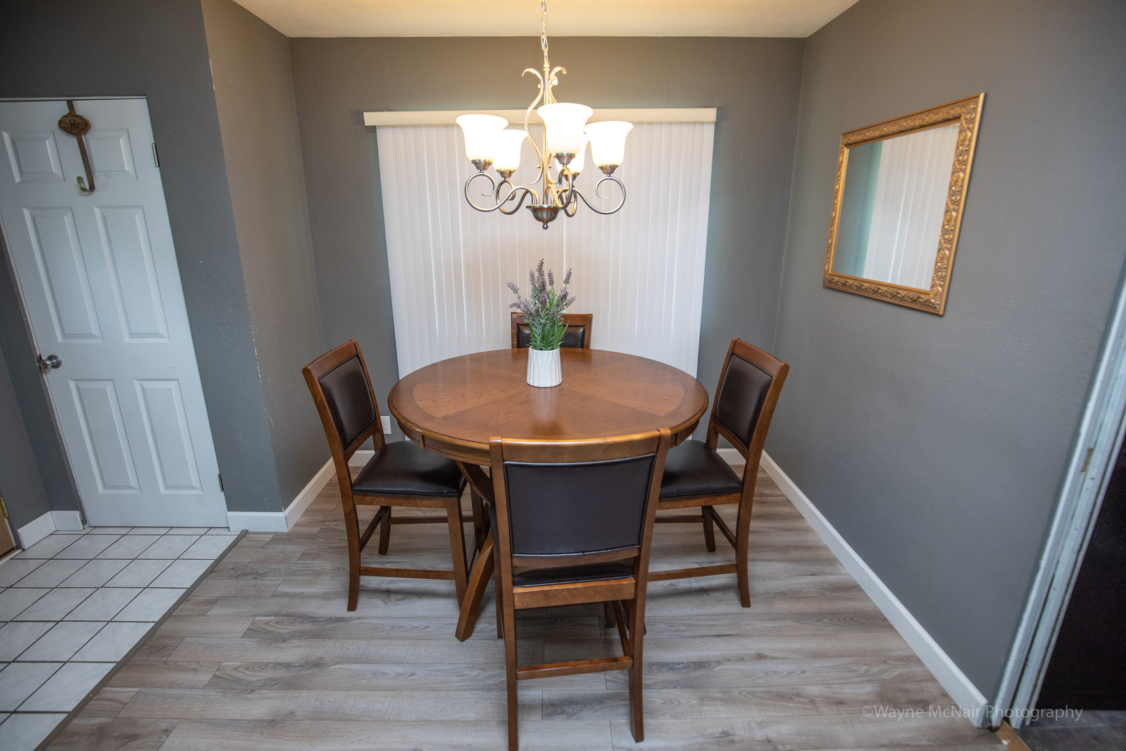 1610 Black Road Joliet, IL 60435 - Photo 6 of 25 a dining room with wooden floor a chandelier a wooden table and chairs