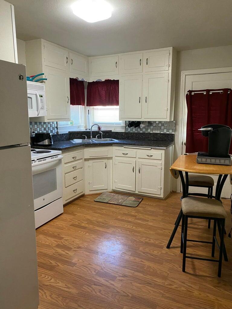 120 Southwest 10th Plainview, TX 79072 - Photo 8 of 27 a kitchen with granite countertop a stove a sink and a refrigerator