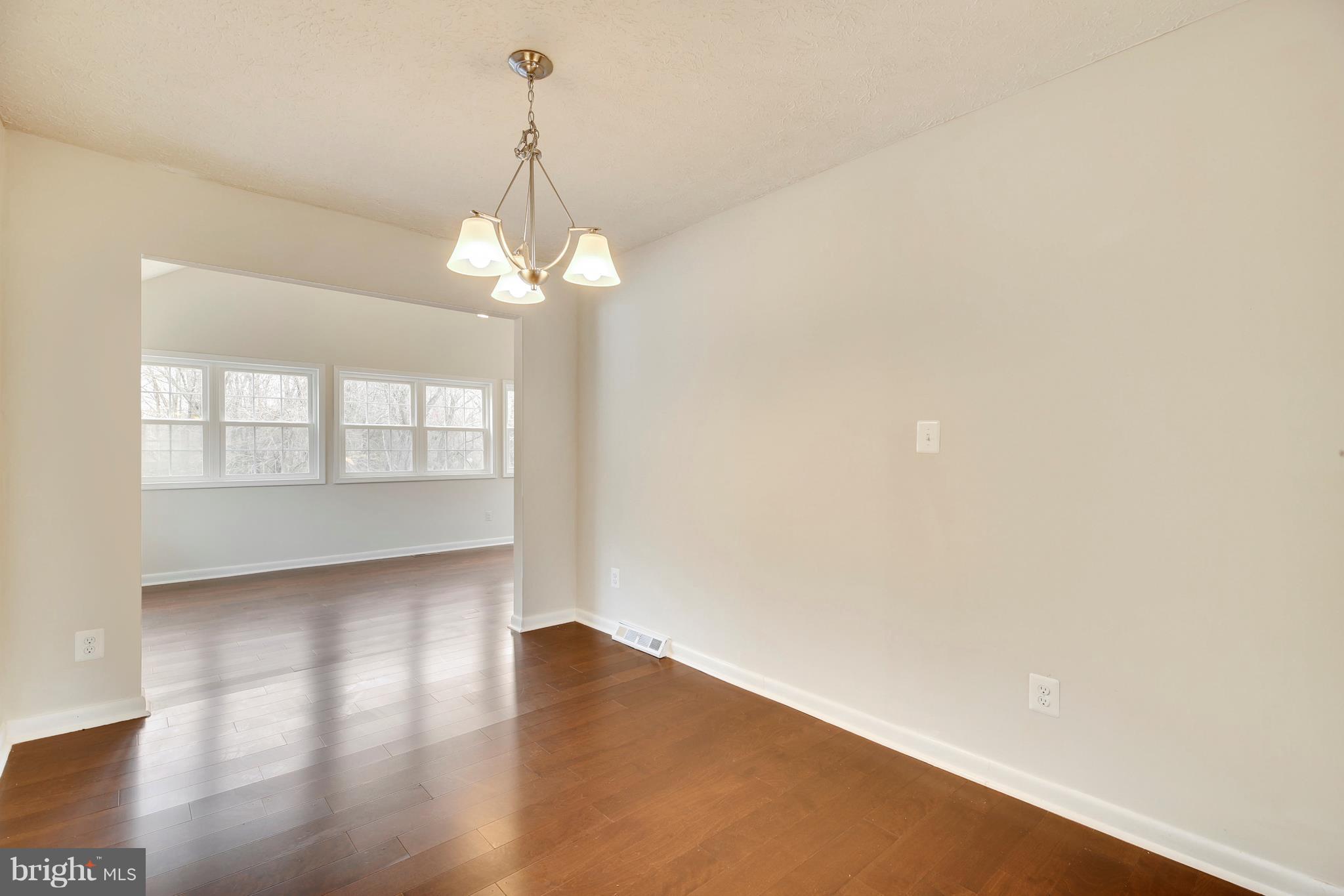 205 Burns Crossing Road Severn, MD 21144 - Photo 5 of 30 a view of an empty room with wooden floor and a window