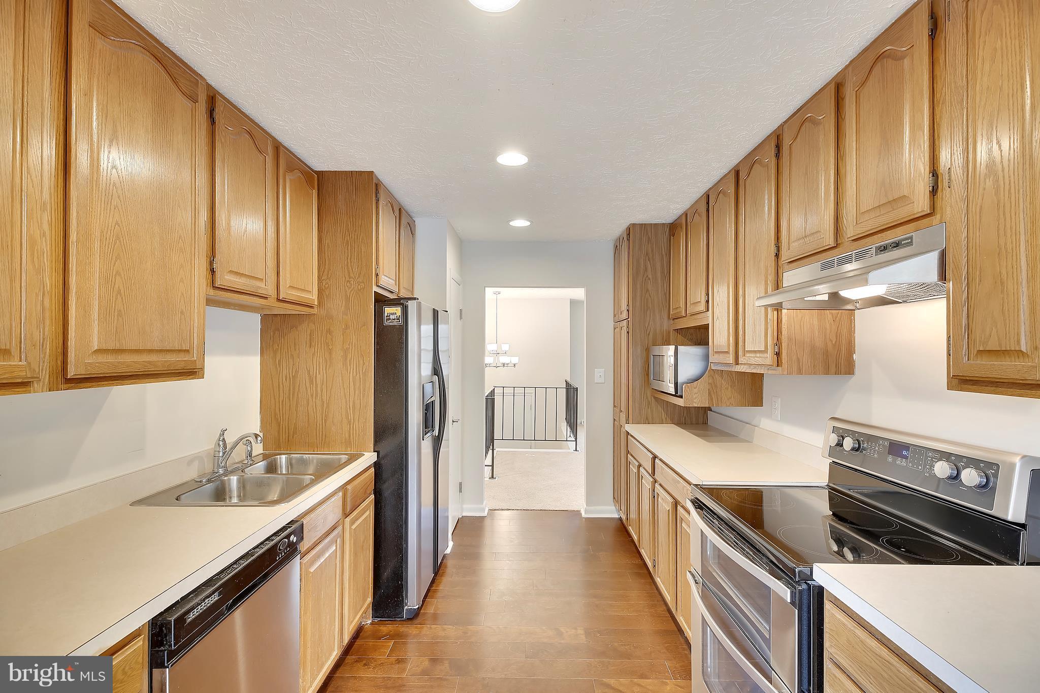 205 Burns Crossing Road Severn, MD 21144 - Photo 7 of 30 a kitchen with granite countertop a sink stove and refrigerator