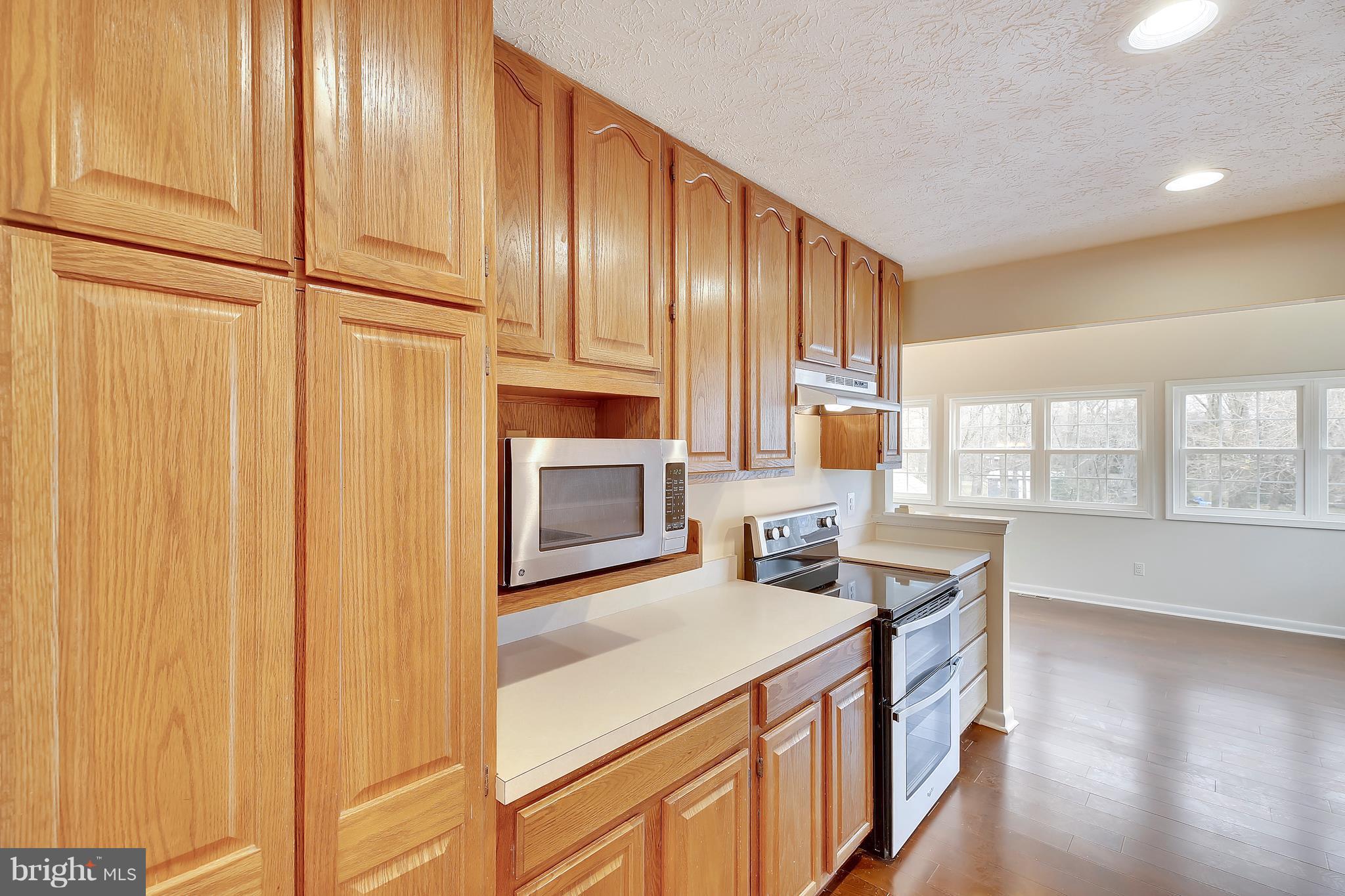 205 Burns Crossing Road Severn, MD 21144 - Photo 8 of 30 a kitchen with stainless steel appliances granite countertop a stove a sink and a refrigerator with wooden floor