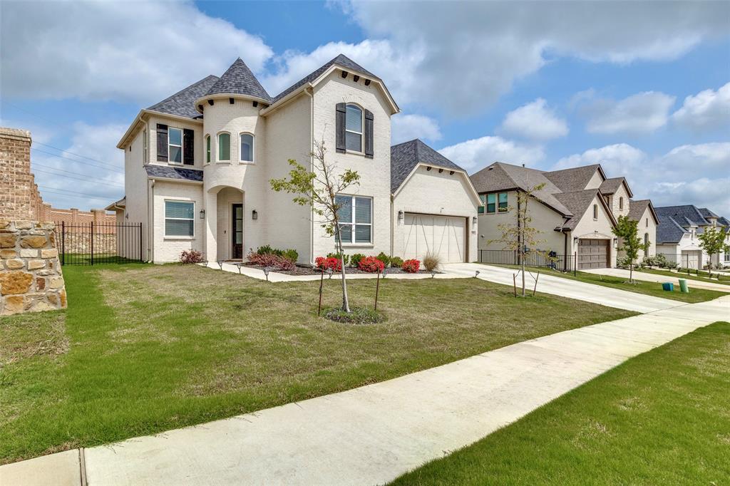 French country home featuring concrete driveway, a residential view, and an attached garage