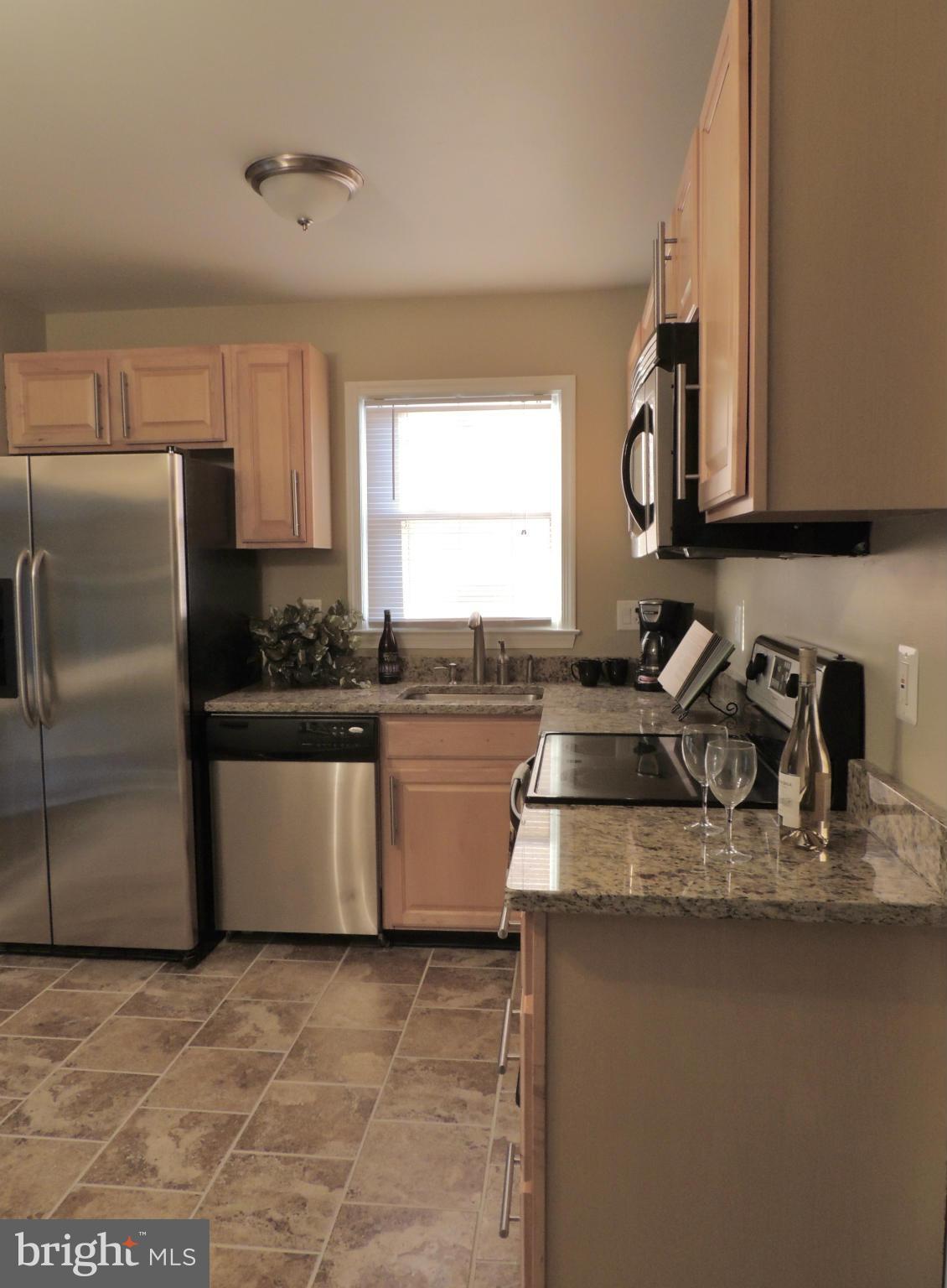 4803 Ebenezer Road Nottingham, MD 21236 - Photo 17 of 29 a kitchen with stainless steel appliances granite countertop a sink a stove and a refrigerator