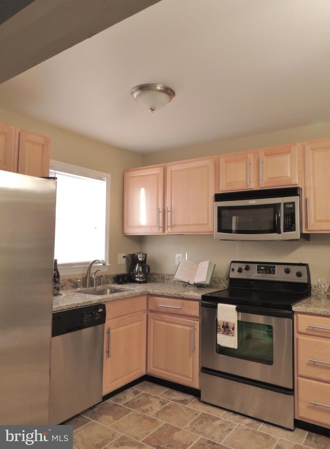 4803 Ebenezer Road Nottingham, MD 21236 - Photo 6 of 29 a kitchen with stainless steel appliances granite countertop a stove a sink and a microwave