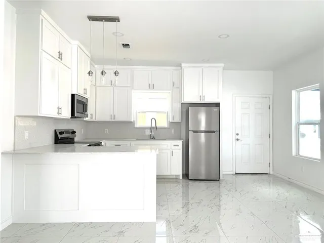 a kitchen with a sink a refrigerator and a stove
