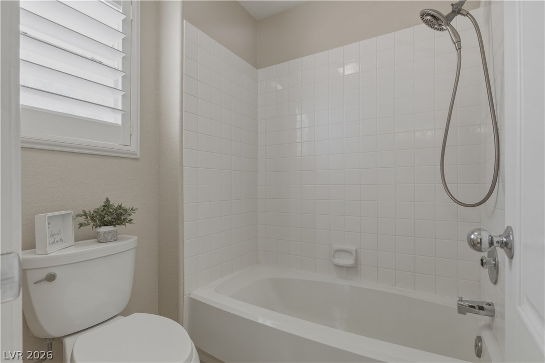 29 Olive Tree Henderson, NV 89074 - Photo 39 of 60 This bathroom features a sleek bathtub with white tiled walls, offering a clean and functional design.