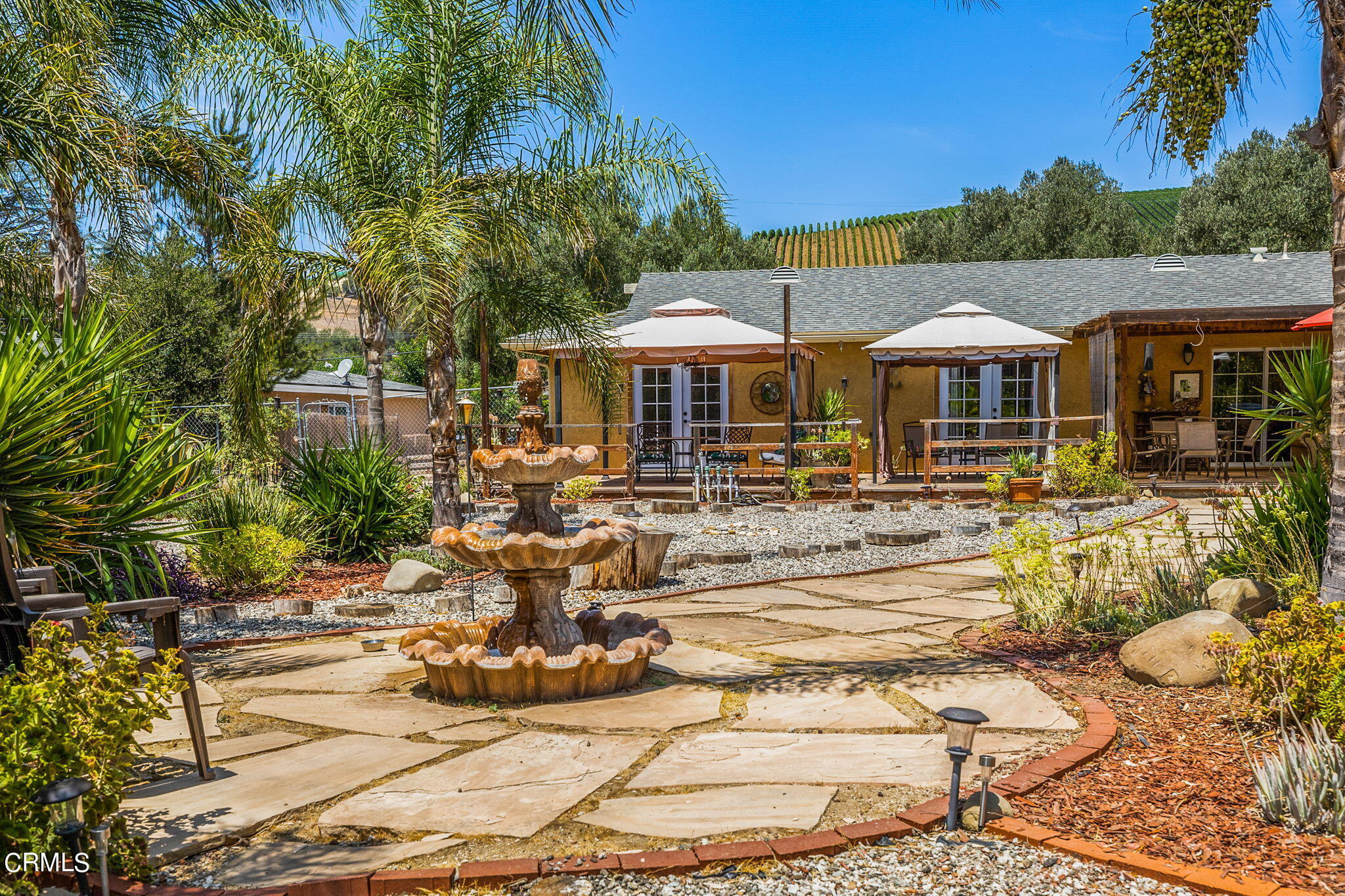 52 Grapevine Road Oak View, CA 93022 - Photo 31 of 52 a view of a white house with swimming pool lawn chairs under an umbrella