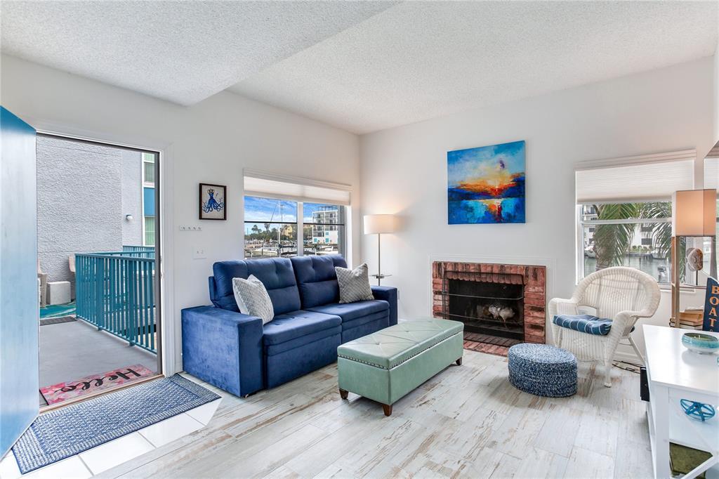 171 Medallion Boulevard, Unit H Madeira Beach, FL 33708 - Photo 11 of 44 a living room with furniture and a fireplace