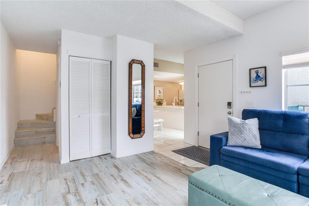 171 Medallion Boulevard, Unit H Madeira Beach, FL 33708 - Photo 16 of 44 a living room with furniture and a wooden floor