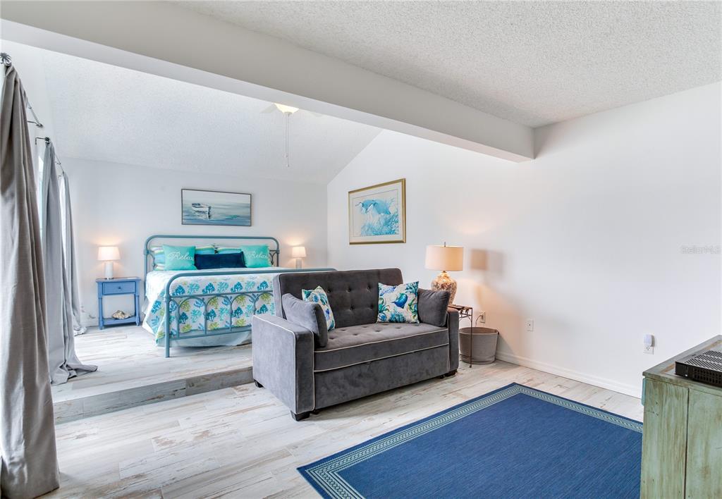 171 Medallion Boulevard, Unit H Madeira Beach, FL 33708 - Photo 18 of 44 a living room with furniture and a wooden floor