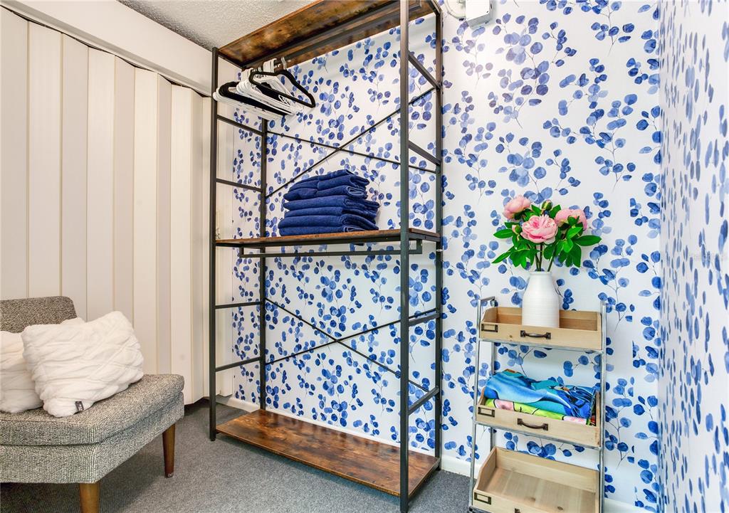 171 Medallion Boulevard, Unit H Madeira Beach, FL 33708 - Photo 24 of 44 a bedroom with a bed and a chair