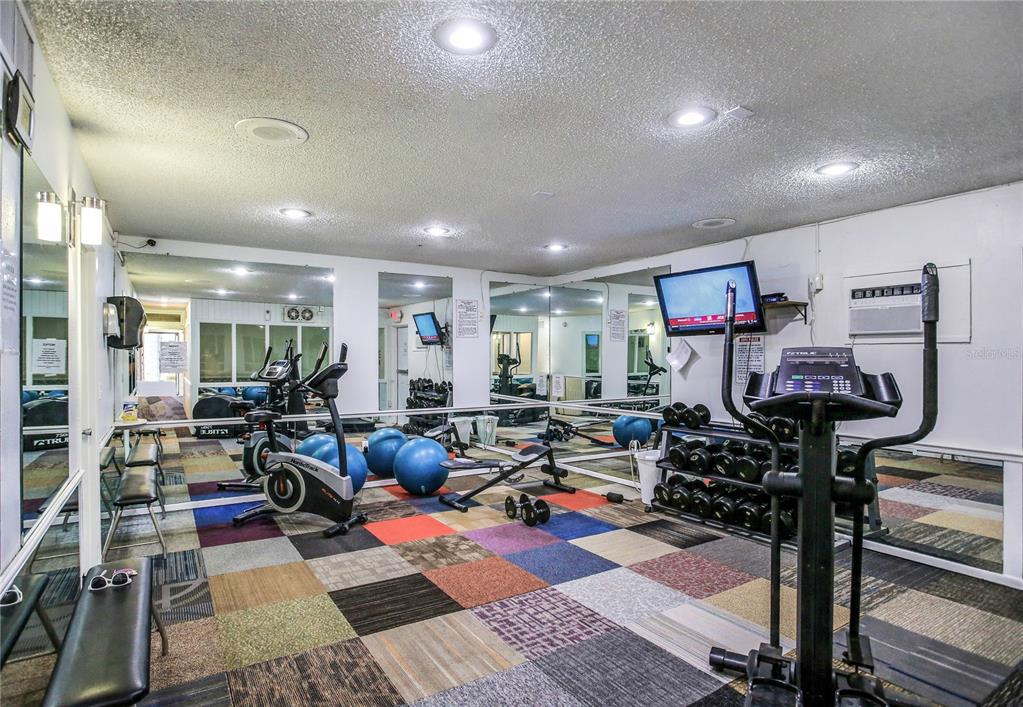 171 Medallion Boulevard, Unit H Madeira Beach, FL 33708 - Photo 29 of 44 a living room with lots of furniture and a wooden floor