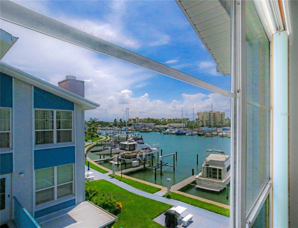 171 Medallion Boulevard, Unit H Madeira Beach, FL 33708 - Photo 5 of 44 a view of a balcony with chair and a potted plant