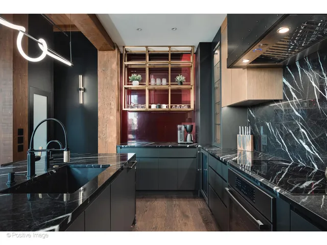 a kitchen with a sink and a stove top oven with wooden floor