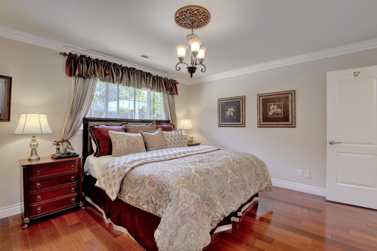 1042 Celilo Drive Sunnyvale, CA 94087 - Photo 14 of 27 a bedroom with bed and a chandelier