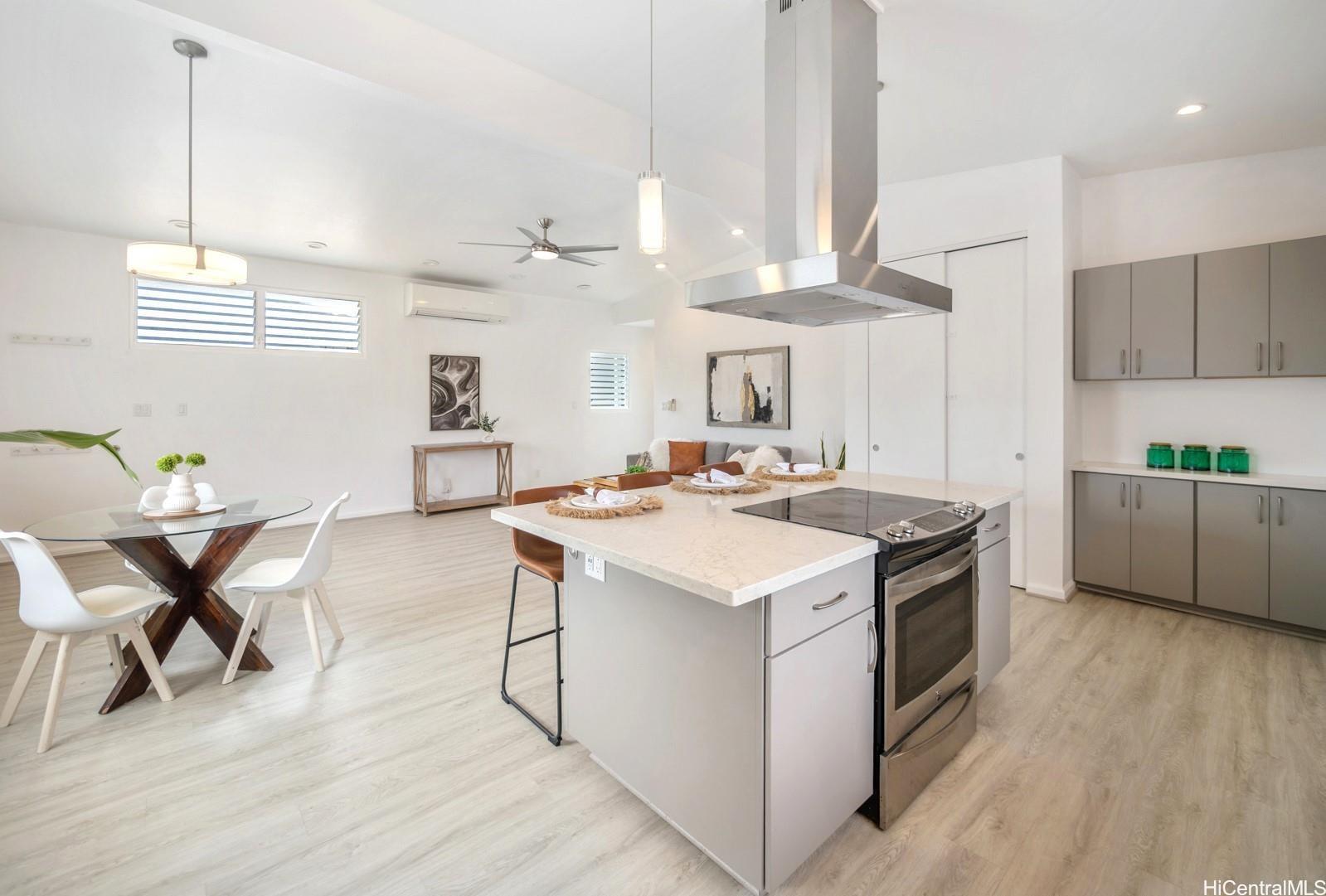 45-185 Lilipuna Road, Unit A Kaneohe, HI 96744 - Photo 11 of 22 a kitchen with stainless steel appliances a stove a sink a dining table and chairs with wooden floor