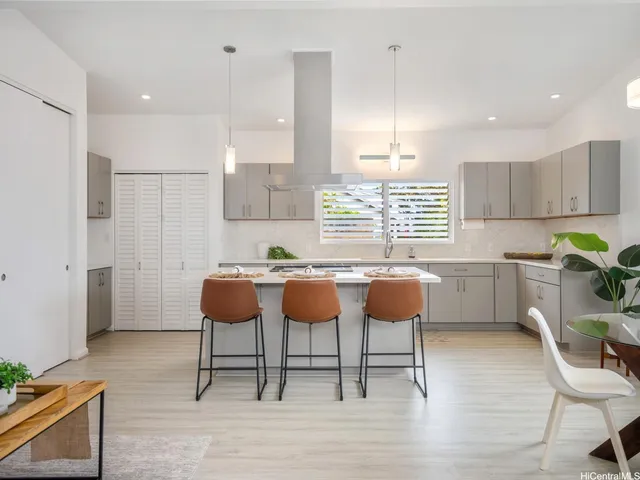 a kitchen with a dining table chairs and white cabinets