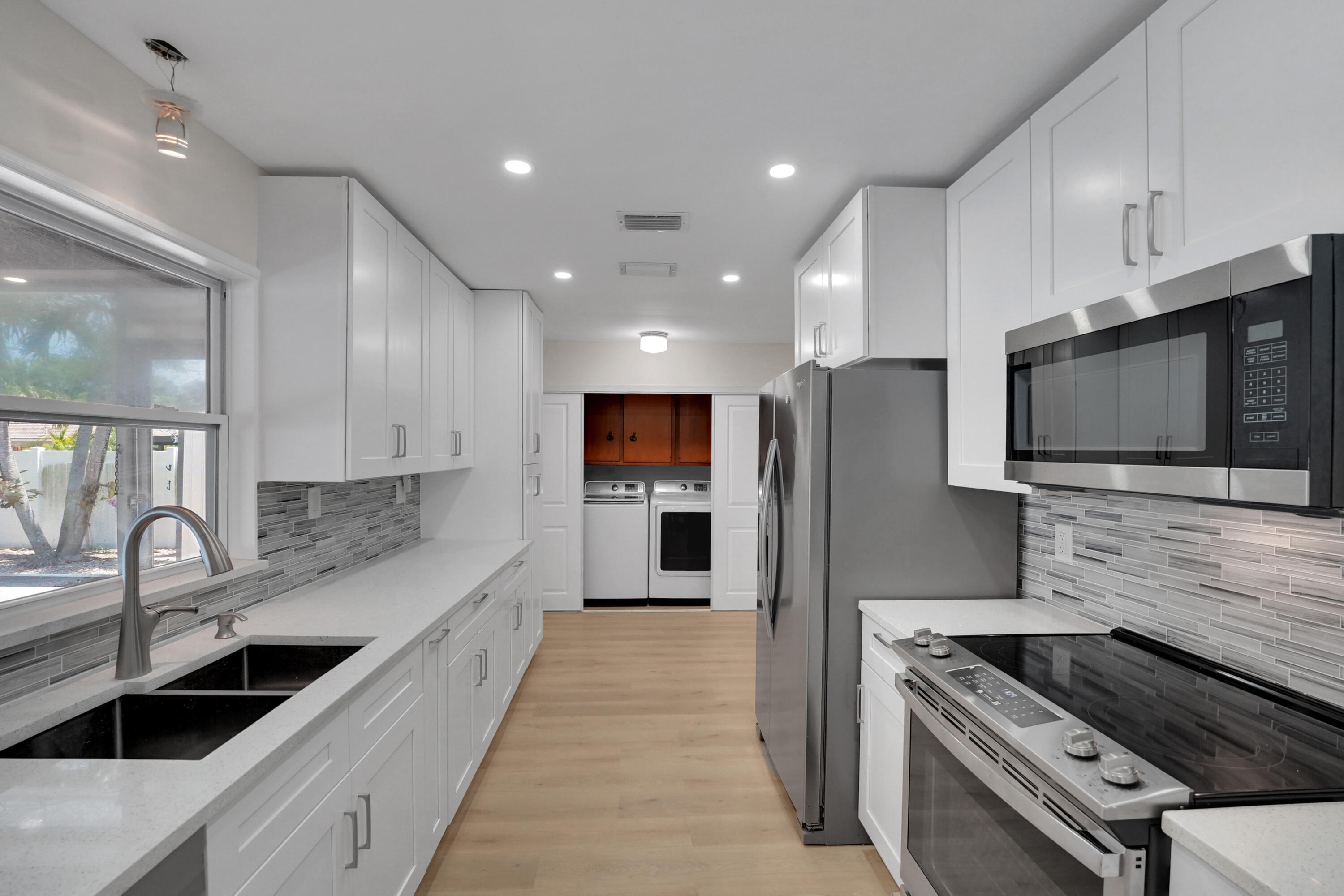 600 Northwest 12th Avenue Boca Raton, FL 33486 - Photo 13 of 63 a kitchen with stainless steel appliances granite countertop a sink and stove top oven