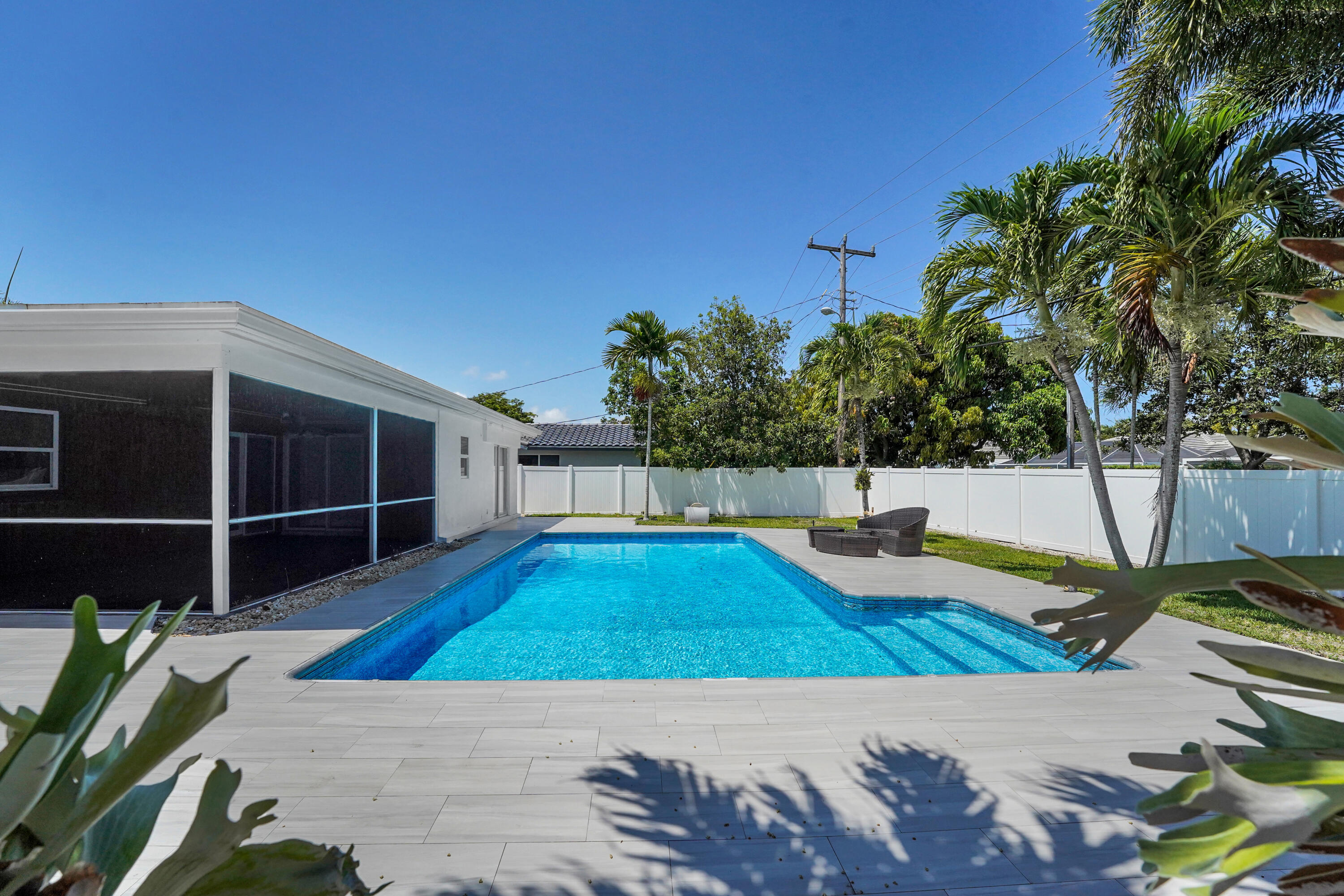 600 Northwest 12th Avenue Boca Raton, FL 33486 - Photo 50 of 63 a view of a backyard with lawn chairs potted plants and wooden fence