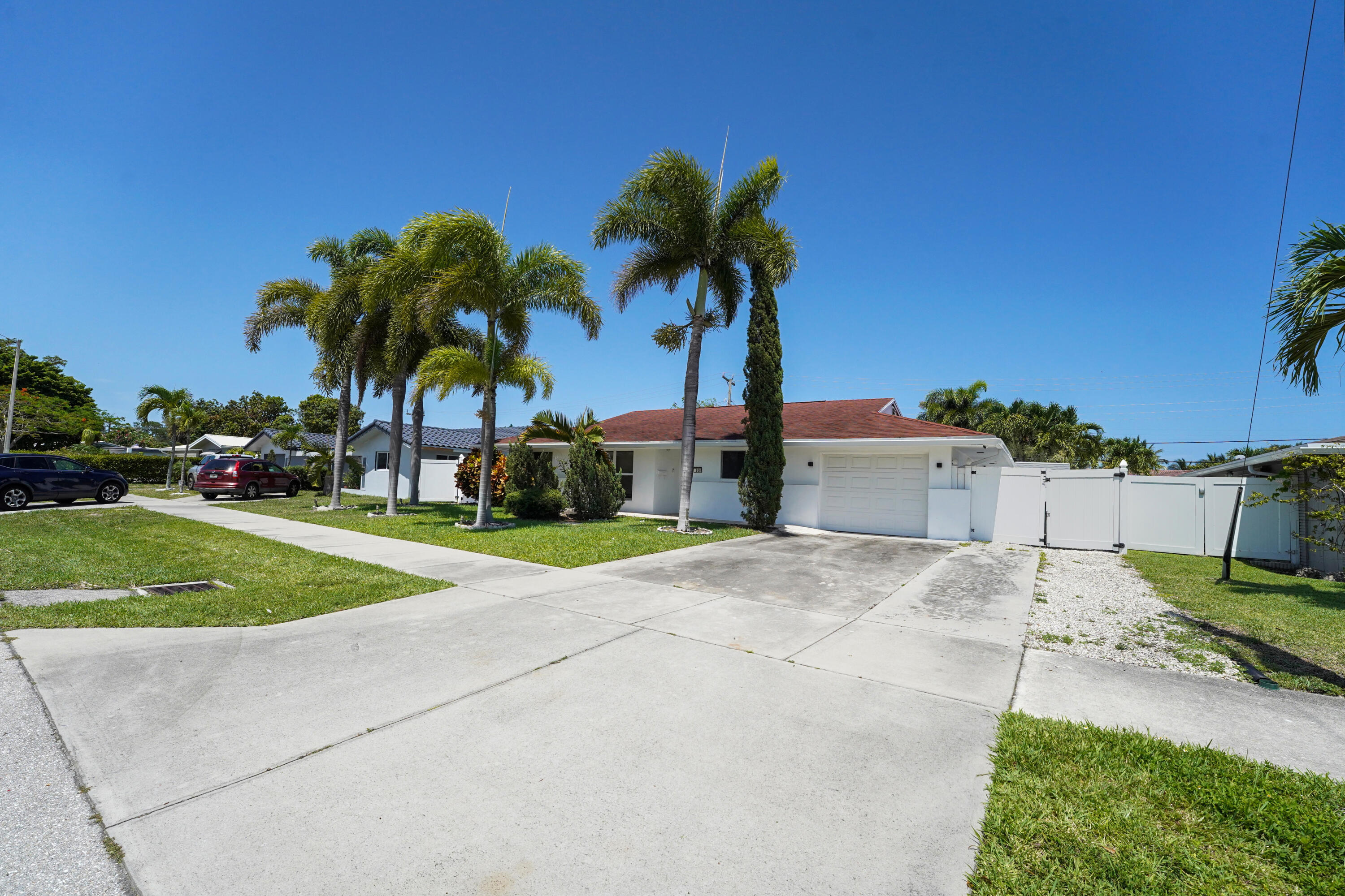 600 Northwest 12th Avenue Boca Raton, FL 33486 - Photo 60 of 63 a palm tree sitting in front of a house with a yard