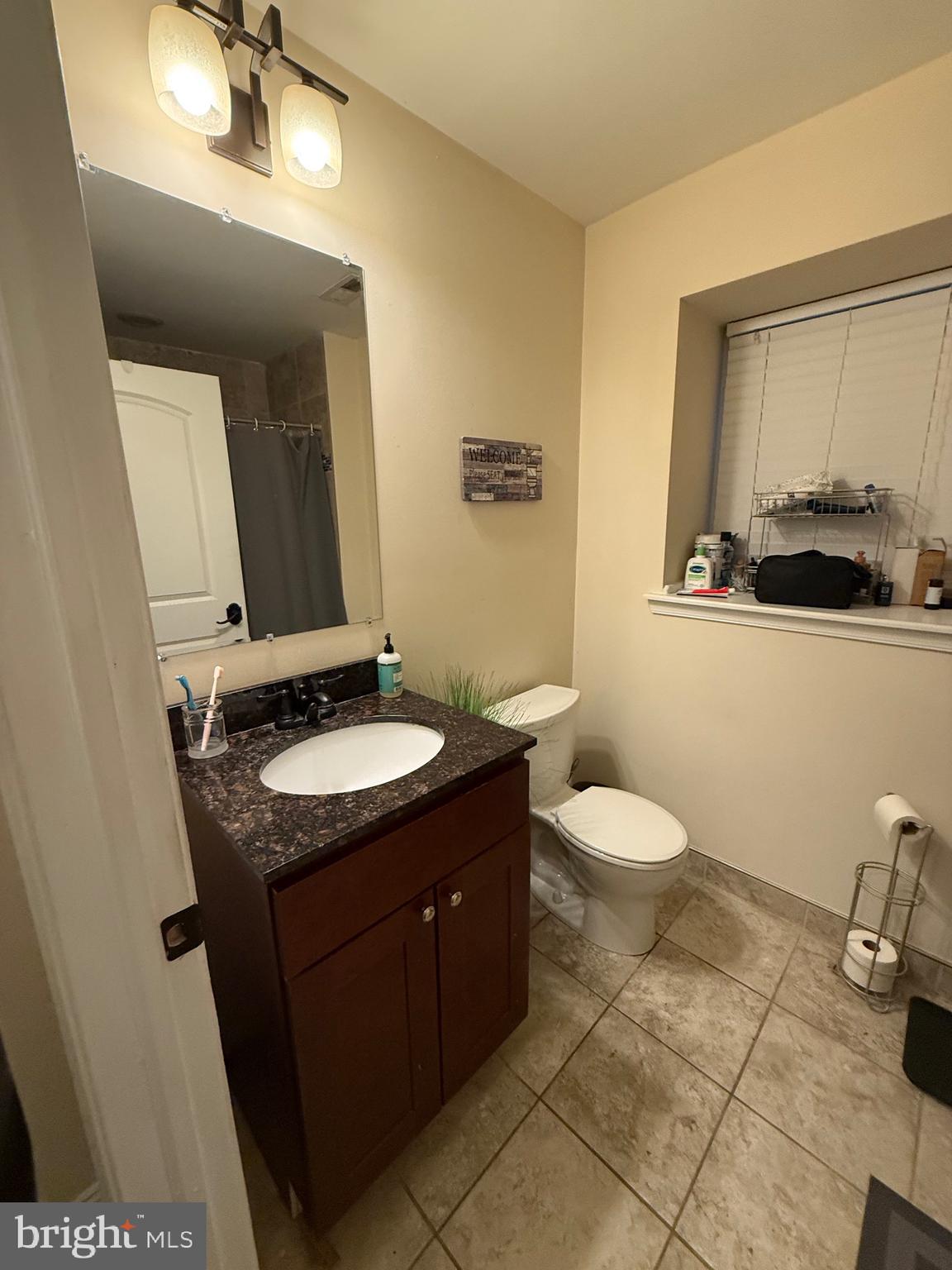 6110 Ridge Avenue Philadelphia, PA 19128 - Photo 8 of 9 a bathroom with a granite countertop sink toilet and mirror