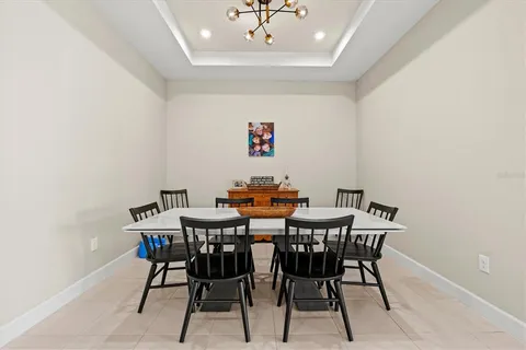 a kitchen with a dining table chairs and a refrigerator