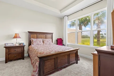 a bed sitting in a bedroom next to a window