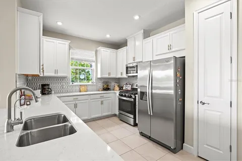 a kitchen with a refrigerator sink and cabinets