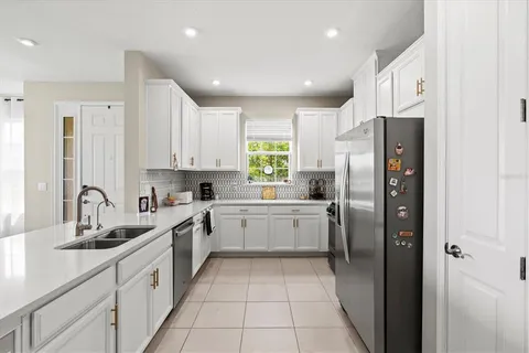 a kitchen with a refrigerator sink and cabinets