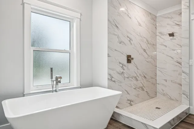 a bathroom with a tub shower sink and vanity