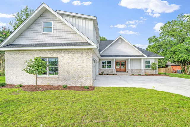 a front view of a house with a garden and plants
