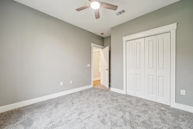 an empty room with a ceiling fan and a window