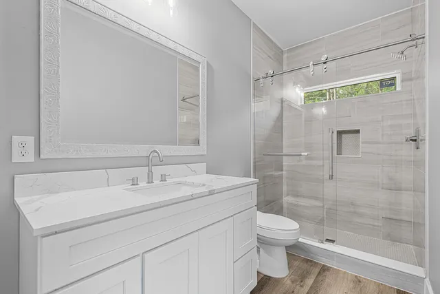 a bathroom with a sink toilet double vanity and shower