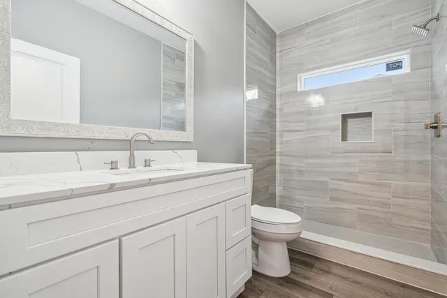 a bathroom with a sink a toilet and shower