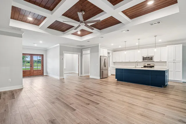 a large room with wooden floors and kitchen view