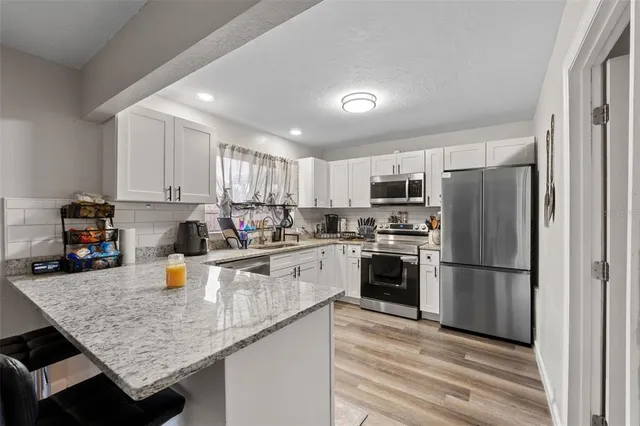 a kitchen with a sink a refrigerator a microwave and cabinets
