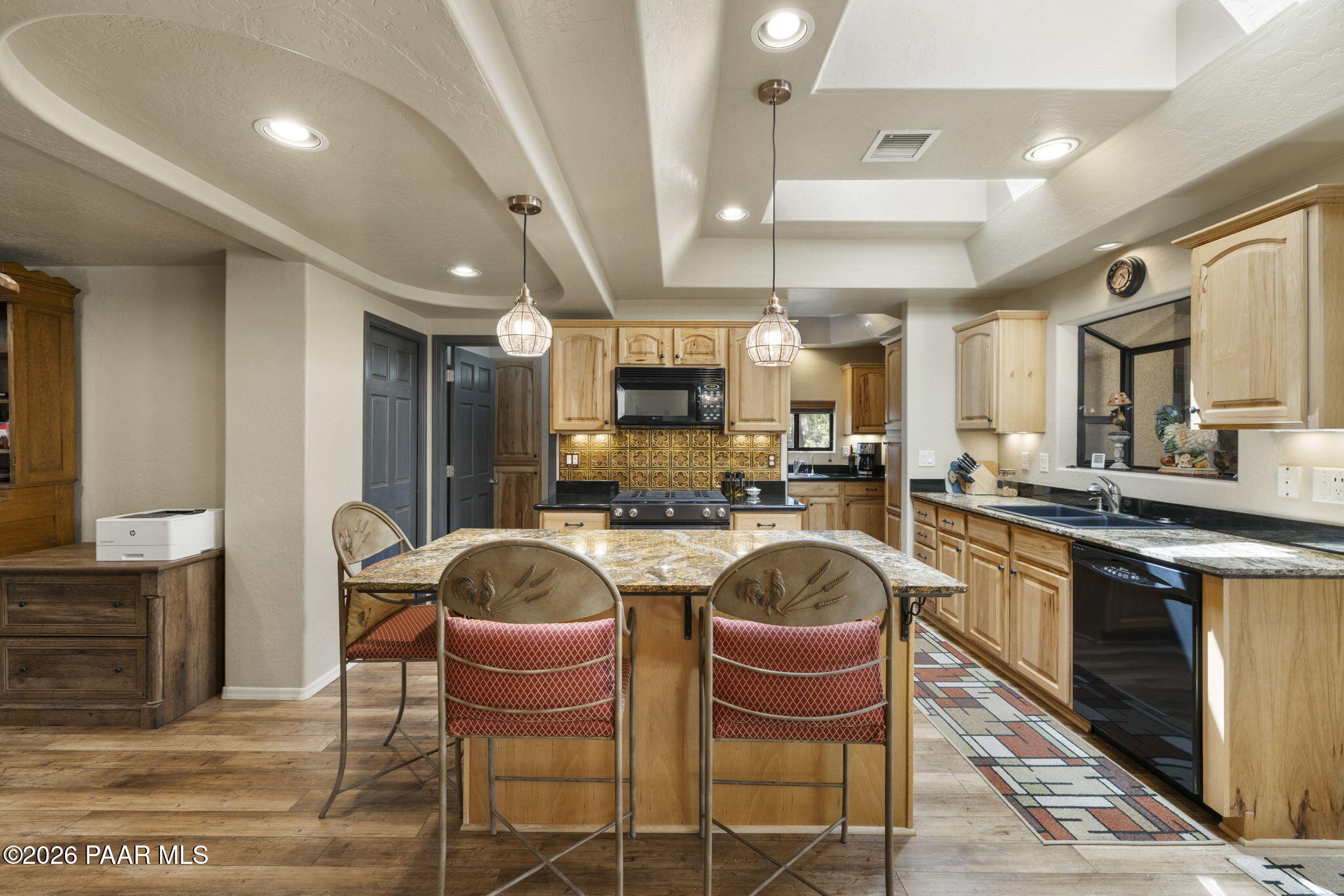 535 Copper Basin Road Prescott, AZ 86303 - Photo 14 of 41 a kitchen with stainless steel appliances granite countertop a stove top oven a sink dishwasher a dining table and chairs with wooden floor