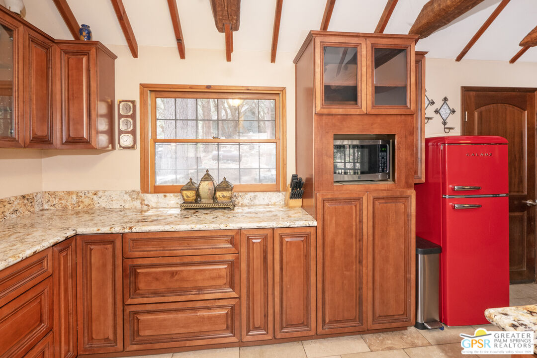 76 7 Oaks Road Angelus Oaks, CA 92305 - Photo 8 of 35 a kitchen with granite countertop a oven and a sink with wooden cabinets