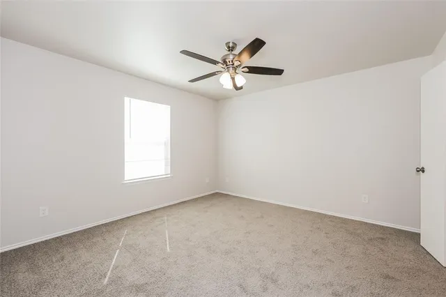 an empty room with a window and a fan