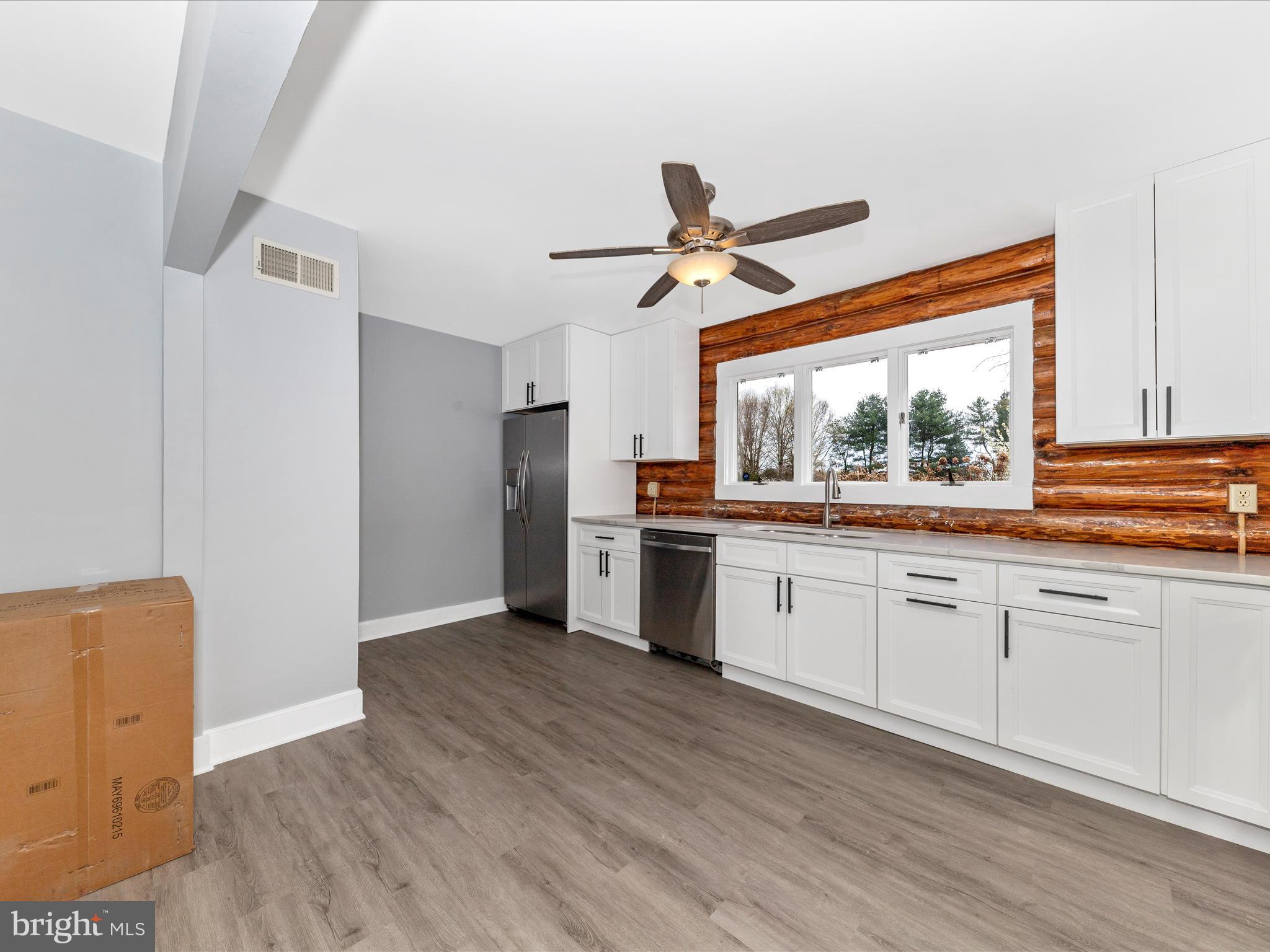 9513 Huntmaster Road Gaithersburg, MD 20882 - Photo 14 of 51 a kitchen with stainless steel appliances white cabinets and wooden floors