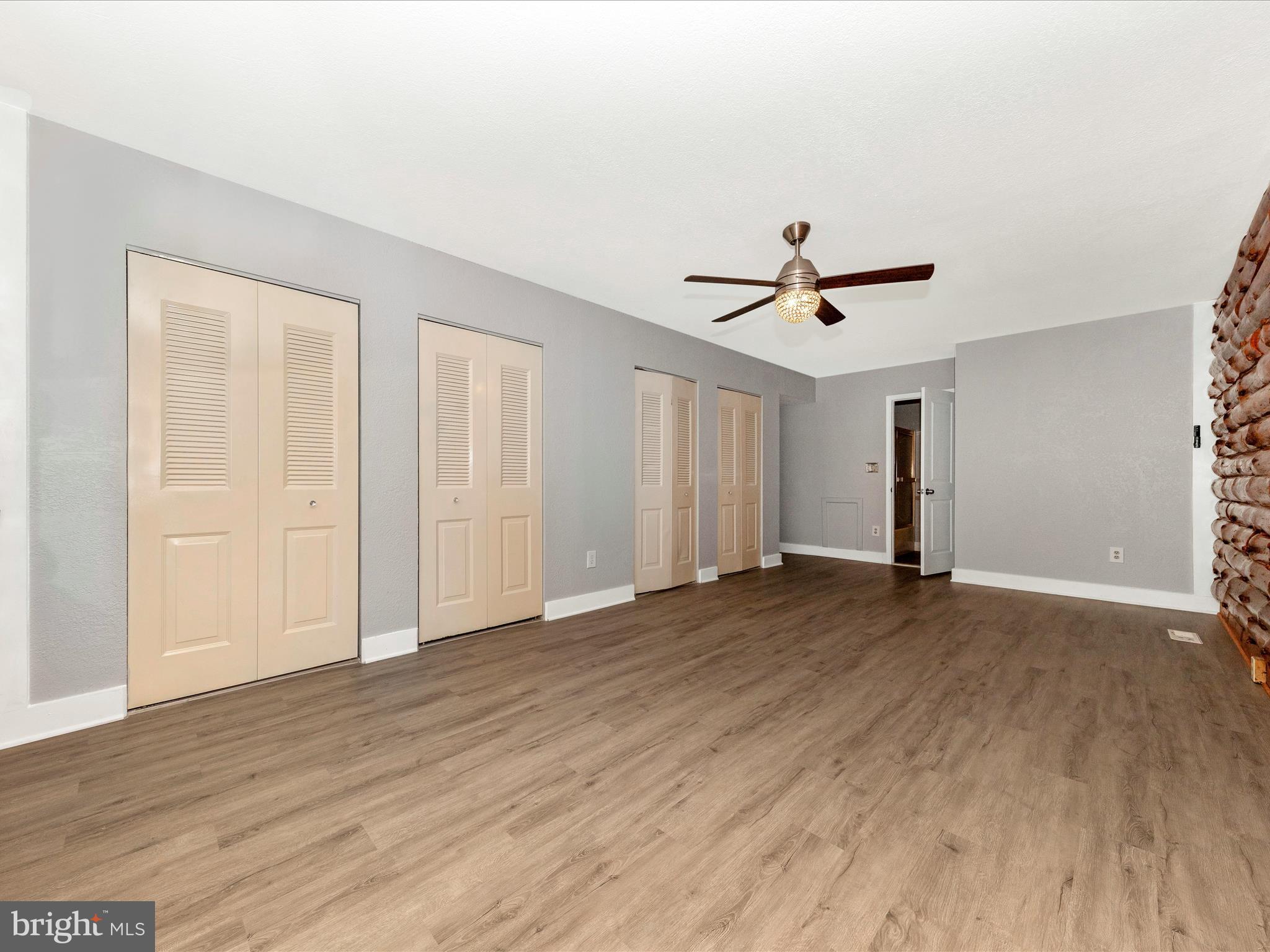 9513 Huntmaster Road Gaithersburg, MD 20882 - Photo 18 of 51 a view of an empty room with wooden floor and a ceiling fan